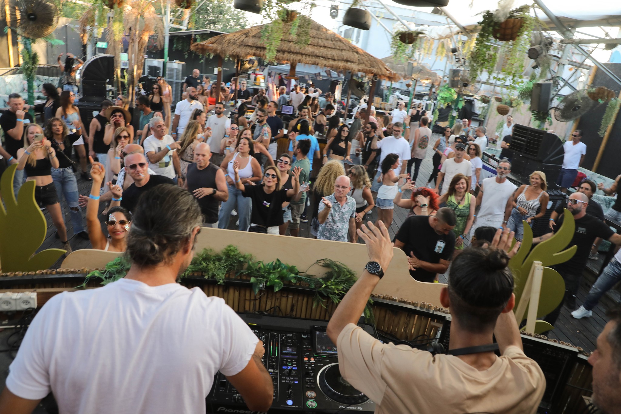 ShiBass behind the DJ booth with a crowd in front